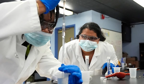 Sima Gutierrez, right, observes as a teammate examines water at the Flint Community Water Lab, Wednesday, April 3, 2024, in Flint, Mich. (AP)