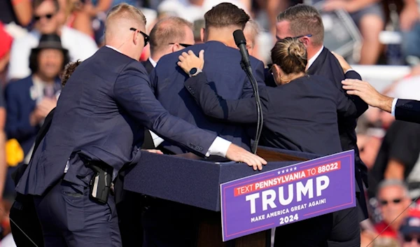 Republican presidential candidate former President Donald Trump is surrounded by U.S. Secret Service at a campaign event in Butler, Pa., on Saturday, July 13, 2024. (AP Photo/Gene J. Puskar)