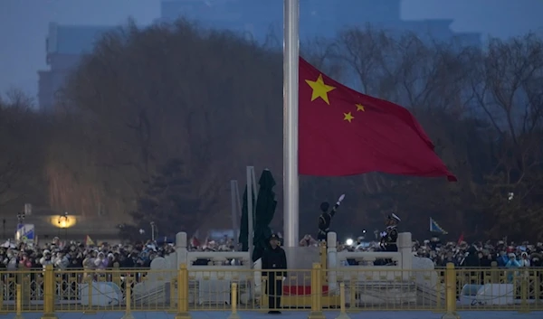 A member of the Chinese honor guard unfurls the Chinese national flag during a flag raising ceremony at the Tiananmen Square in Beijing, China, Tuesday, March 5, 2024. (AP Photo)