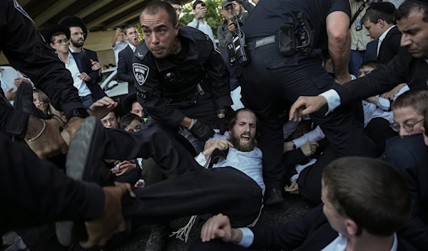 Israeli police disperse ultra-Orthodox Jews blocking a highway during a protest against army recruitment in Bnei Brak, occupied Palestine, Thursday, June 27, 2024. (AP)