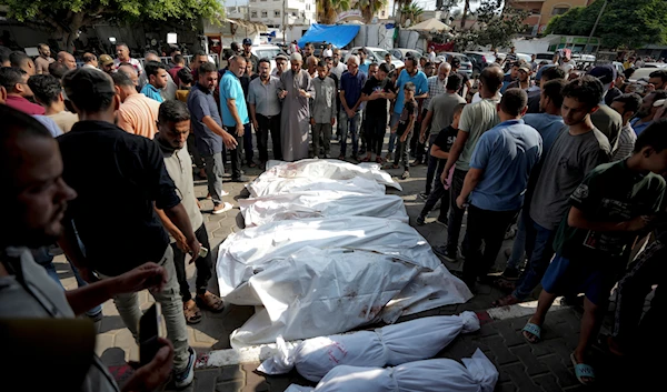 Palestinians gather near the bodies of their relatives killed in the Israeli bombardment of the Gaza Strip, at a hospital morgue in Deir al-Balah, Tuesday, July 16, 2024. (AP)