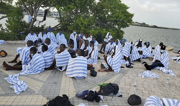 Haitian migrants on shore wrapped in towels after a boat ran aground in the Florida Keys off Key Largo on Sunday, March 6, 2022. (AP)