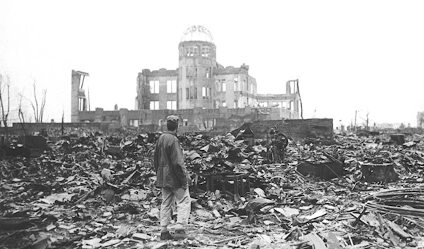 In this 1945 file photo, an Allied war correspondent stands in the ruins of Hiroshima, Japan, just weeks after the city was leveled by an atomic bomb. (AP)