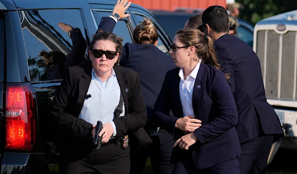 U.S. Secret Service agents surround the vehicle carrying Republican presidential candidate former President Donald Trump at a campaign rally, Saturday, July 13, 2024, in Butler, Pa. (AP)