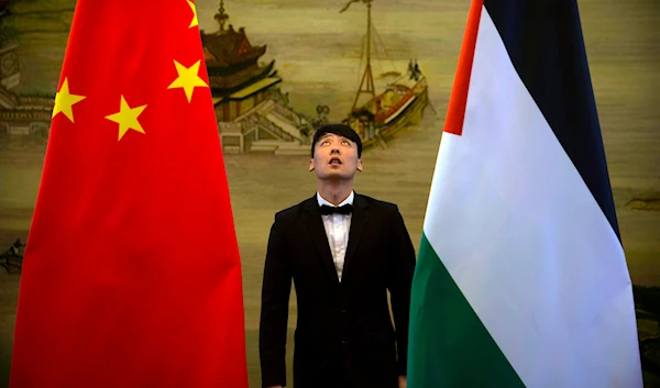 A staff member checks the alignment of Chinese, left, and Palestinian flags before the start of a joint press conference at the Ministry of Foreign Affairs in Beijing, China, April 13, 2017 (AP)