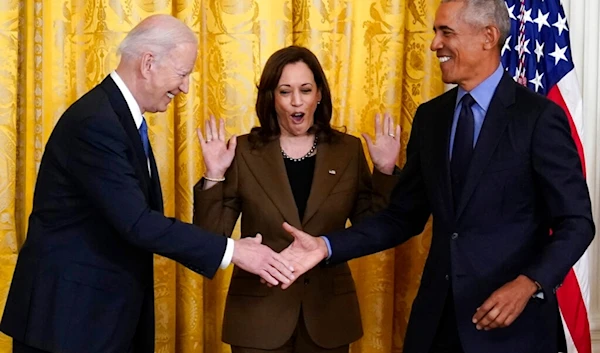 Vice President Kamala Harris reacts as President Joe Biden and former President Barack Obama shake hands on stage, in the East Room of the White House in Washington, Tuesday, April 5, 2022. (AP)