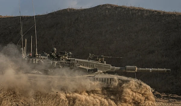 An Israeli soldier moves on the top of a tank near the Israeli-Gaza border, as seen from southern Israel, Sunday, July 14, 2024. (AP Photo/Tsafrir Abayov)