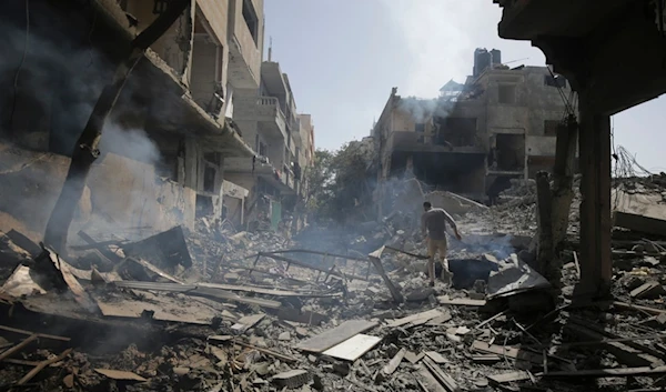 Palestinians look at the aftermath of the Israeli bombing in Nuseirat refugee camp, Gaza Strip, Saturday, June 8, 2024. (AP Photo/Jehad Alshrafi)