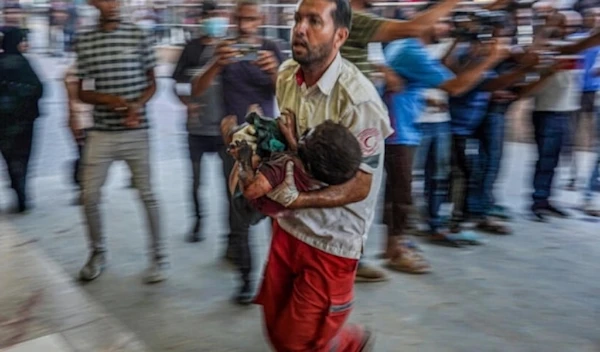 A paramedic carries a Palestinian child wounded during Israeli bombardment to the emergency ward at the Nasser Hospital in Khan Younis southern Gaza Strip, July 9,2024. (AFP)