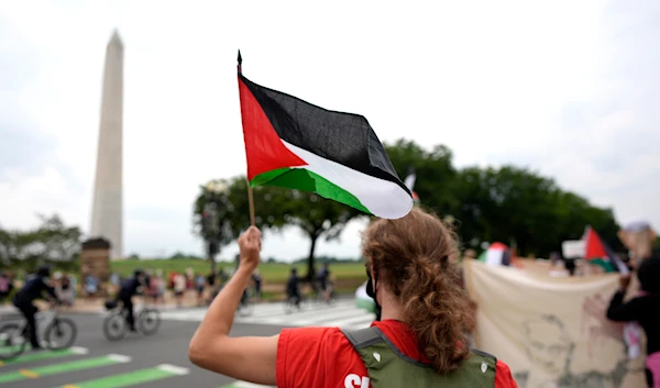 A demonstrator waves a Palestinian flag near the Washington Monument during a rally, Thursday, July 25, 2024, in Washington. (AP)