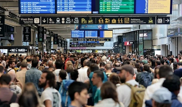 Passengers gather around the departure and arrival boards at the Gare Montparnasse train station in Paris, Undated. (AFP)