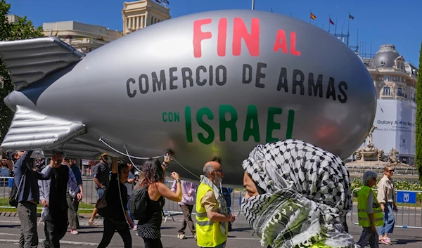 A blimp with the massage ' Stop the arms sales to Israel' is carried during a demonstration to show solidarity with Palestinians during a protest march in Madrid, Spain, Sunday, April 21, 2024. (AP)