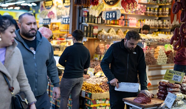 A vendor cuts sausage during of the holy month of Ramadan near Eminönü Square in İstanbul on March 15, 2024. (AFP)