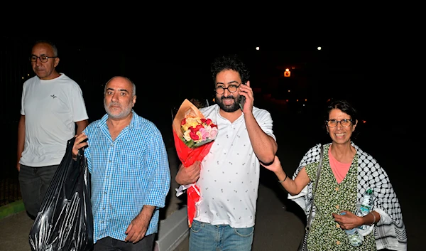 Omar Radi, a journalist and activist, second from right, speaks on the phone after he was pardoned and released from prison in Tifelt, Morocco, on July 29, 2024. (AP)