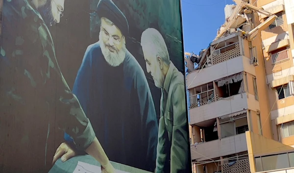 A poster showing Martyr Imad Mughniyeh, left, Hezbollah leader Sayyed Hassan Nasrallah, center, and Martyr Qassem Soleimani is set near the building hit by an Israeli airstrike in the southern suburbs of Beirut, Lebanon, July 31, 2024. (AP)