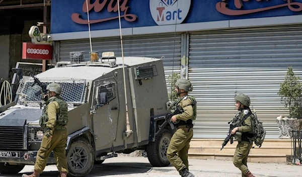 Israeli occupation officers walk back to their vehicles in the Palestinians al-Fara’a refugee camp in the occupied West Bank following the IOF military raid on Monday June 10,2024. (AP)