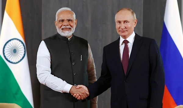 Russian President Vladimir Putin and Indian Prime Minister Narendra Modi pose for a photo shaking hands before their talks on the sidelines of the Shanghai Cooperation Organisation (SCO) summit in Samarkand, Uzbekistan, on September 16, 2022. (AP)