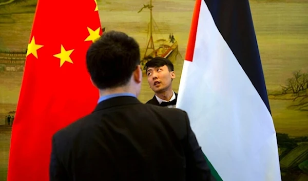 Staff members check the alignment of Chinese, left, and Palestinian flags before the start of a joint press conference at the Ministry of foreign affairs in Beijing, Thursday April 13, 2017. (AP)