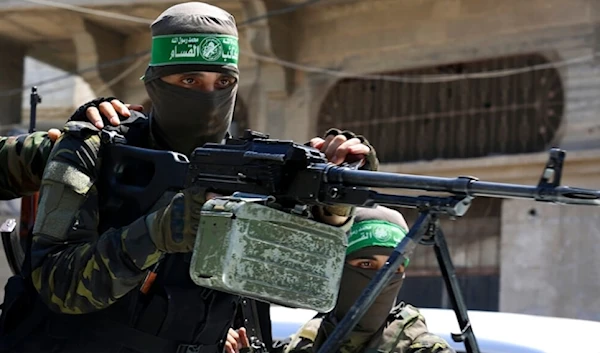 An al-Qassam Brigades Resistance fighter means a machine gun in the Jabalia refugee camp in the northern Gaza Strip, Palestine, on August 25,2021. (AP)