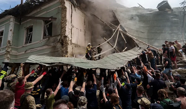 Hundreds of people rush to clear debris at the hospital, where windows are smashed and panels ripped off. July 8, 2024. (AP)