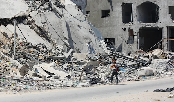 A Palestinian child walking alongside a residential building reduced to rubble by Israeli relentless bombing June 24,2024. (UNRWA)