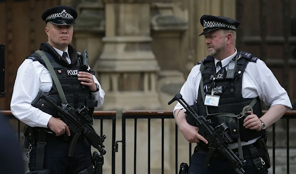 Armed British Police officers stand on duty outside of the Houses of Parliament in Westminster, central London on May 23, 2017. (AFP)