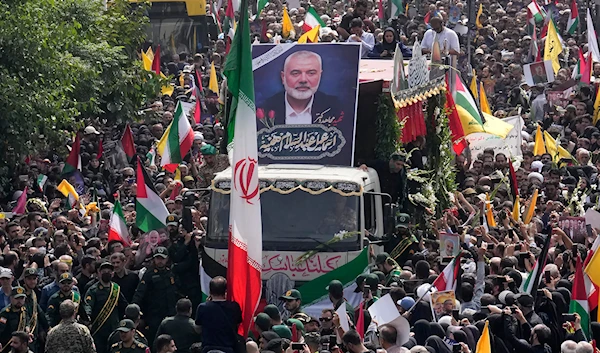 Iranians follow a truck, center, carrying the coffins of Hamas leader Ismail Haniyeh and his bodyguard who were killed in an Israeli assassination, during their funeral ceremony at Enqelab-e-Eslami Sq. in Tehran, Iran, Thursday, August 1, 2024 (AP)