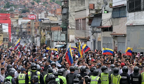 Opponents of Venezuelan President Nicolás Maduro's government protest in front of national police in the Catia neighborhood of Caracas yesterday. (Yuri Cortez/AFP via Getty Images)