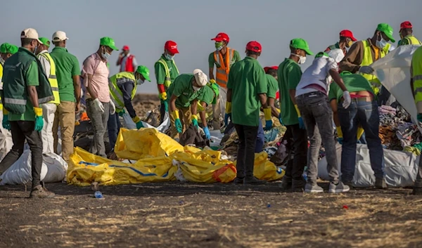 Workers collect debris on March 12, 2019, at the scene where an Ethiopian Airlines Boeing 737 Max 8 crashed shortly after takeoff. (AP)