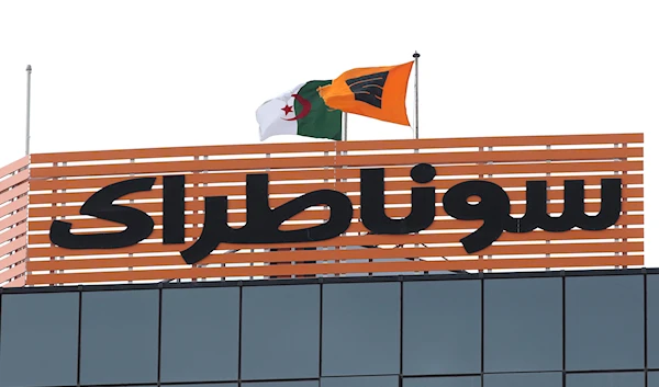 The flag of the Algerian Sonatrach group flies next to the Algerian flag on its headquarters in Algiers, Thursday, February 8, 2018 (AP)