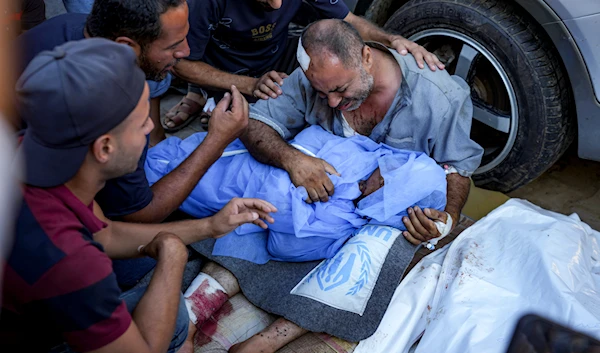 A Palestinian man mourns for a relative killed in the Israeli bombardment of the Gaza Strip, at a hospital in Deir al-Balah, on August 10, 2024. (AP)