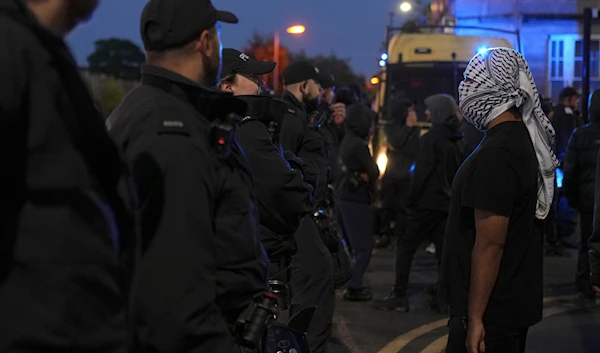 A counter protester stands in front of police in Liverpool, on August 7, 2024. (AP)