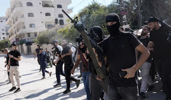 Gunmen attend the funeral of five Palestinians killed by an Israeli strike on a vehicle in the West Bank city of Jenin, Tuesday, August 6, 2024 (AP)