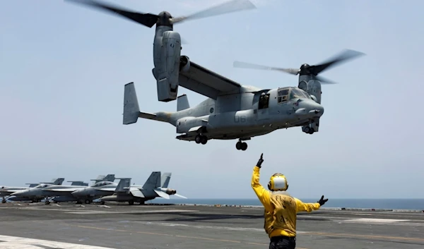 Aviation Boatswain's Mate 2nd Class Nicholas Hawkins signals an MV-22 Osprey to land on the flight deck of the USS Abraham Lincoln in the Arabian Sea on May 17, 2019. (AP/US Navy)