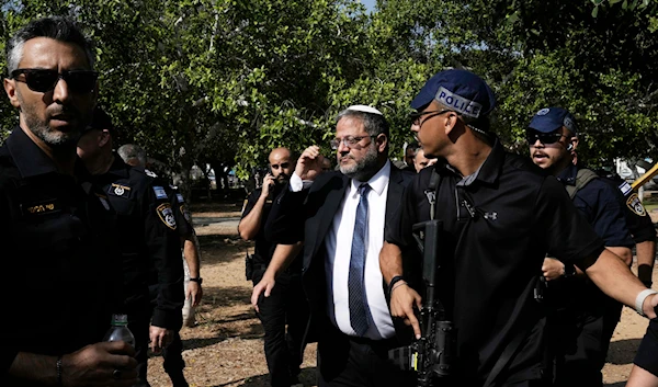 Israel's National Security Minister Itamar Ben-Gvir, center, visits the site of a stabbing attack that, Israeli police said, a Palestinian attacked killed a woman and wounded a few others in Holon, Israel Sunday, August 4, 2024.