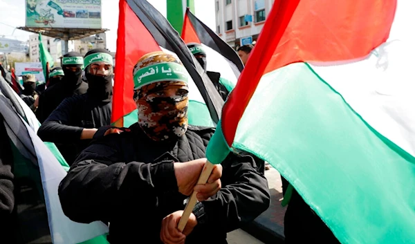 In this Feb. 21, 2020, file photo, masked Hamas fighters wave their national flags during a protest in Gaza City. (AP)