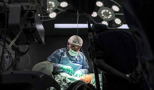 A surgeon operates on a patient in a surgery operating theatre at the Gaza European Hospital in Khan Yunis in the southern Gaza Strip on December 31, 2023. (AFP)