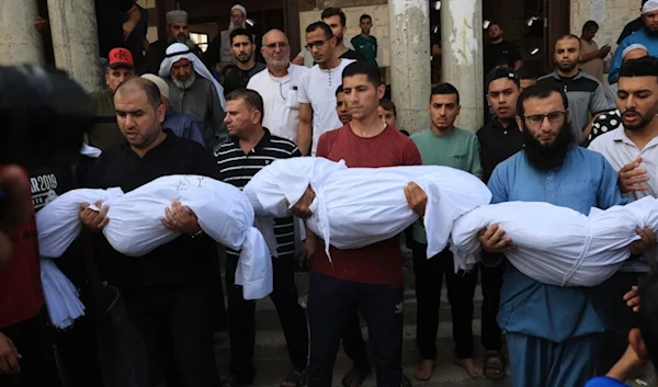 Relatives carry the bodies of children from the Abu Quta family who were killed in Israeli strikes on a residential home in Palestinian city of Rafah in the southern Gaza Strip, during their funeral on October 8, 2023. (AFP/Getty Images)