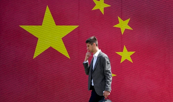 A man walks in front of a Chinese national flag in Belgrade, Serbia, Tuesday, May 7, 2024. (AP)