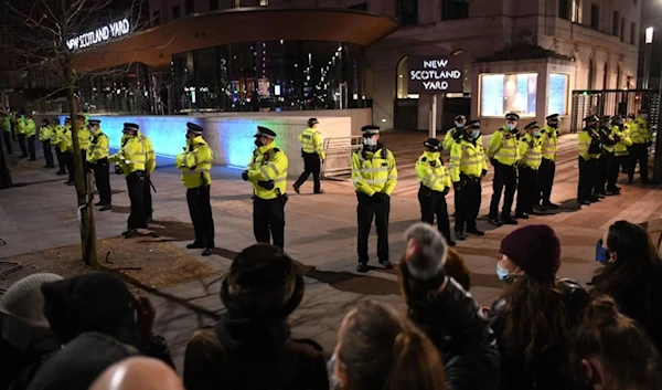 Police officers form a cordon at New Scotland Yard, the headquarters of the Metropolitan Police Service, in central London on March 14, 2021. (AFP)