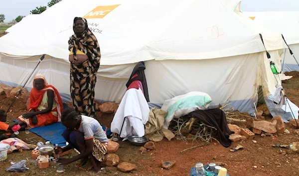 Women and children sit outside their tent, set up at a camp for internally displaced Sudanese from Sennar state, in the al-Huri district of Gedaref city east of war-torn Sudan on July 14,202. (AFP)