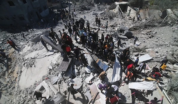 Palestinians search for their relatives under the rubble of a residential building destroyed by an Israeli strike in Rafah, Gaza Strip, Wednesday, March 20, 2024. (AP)