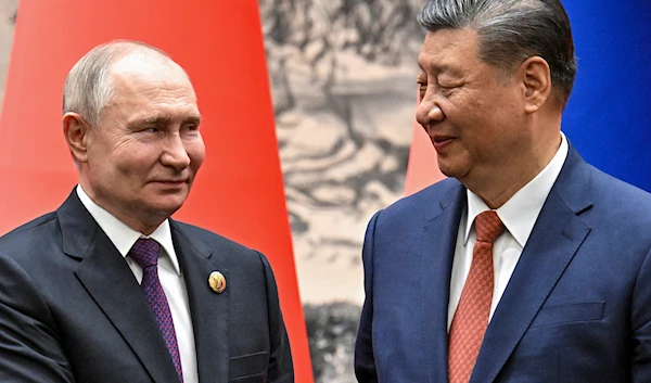 Chinese President Xi Jinping, right, and Russian President Vladimir Putin look toward each other as they shake hands prior to their talks in Beijing, China, Thursday, May 16, 2024. (AP)