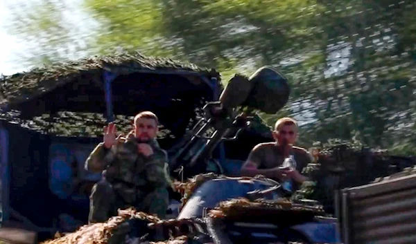 Russian soldiers sit in a military truck as a column of the Russian Armed Forces move to build up forces conducting active combat operations in the Sudzhansky district of Kursk region of Russia. (AP)