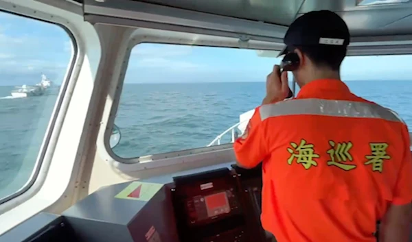 A Taiwanese Coast Guard Administration member calls out for a Chinese Coast Guard ship at left to leave from the area around Kinmen, July 11, 2024. (Taiwan Coast Guard Administration via AP)