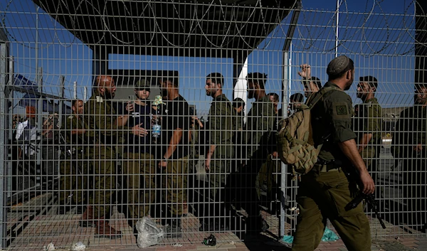 Israeli soldiers gather at the gate to the Sde Teiman detention camp and military base, Monday, occupied Palestine, July 29, 2024 (AP)