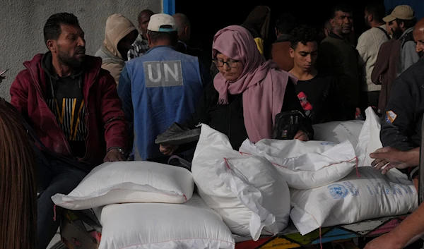 Palestinians take wheat from a UN distribution center in the al-Bureij refugee camp in the Gaza Strip on December 10, 2023. (AP)