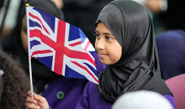 A girl from the Olive School waves a flag of the United Kingdom during a national Muslim memorial at the central mosque in London, England, Sept. 15, 2022. (AP)