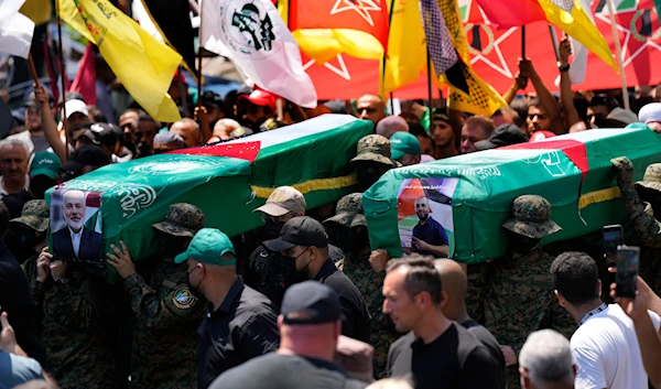 Hamas fighters carry mock coffins of Hamas political chief Ismail Haniyeh and his bodyguard who was killed in an assassination in Tehran, during a symbolic funeral in Beirut, Lebanon, Friday, August 2, 2024 (AP)