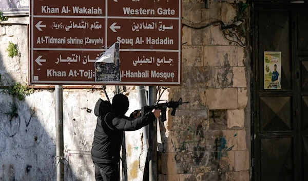 A masked Palestinian fighter fires confronts Israeli occupation forces in the West Bank city of Nablus. Friday, Dec. 30, 2022. (AP)